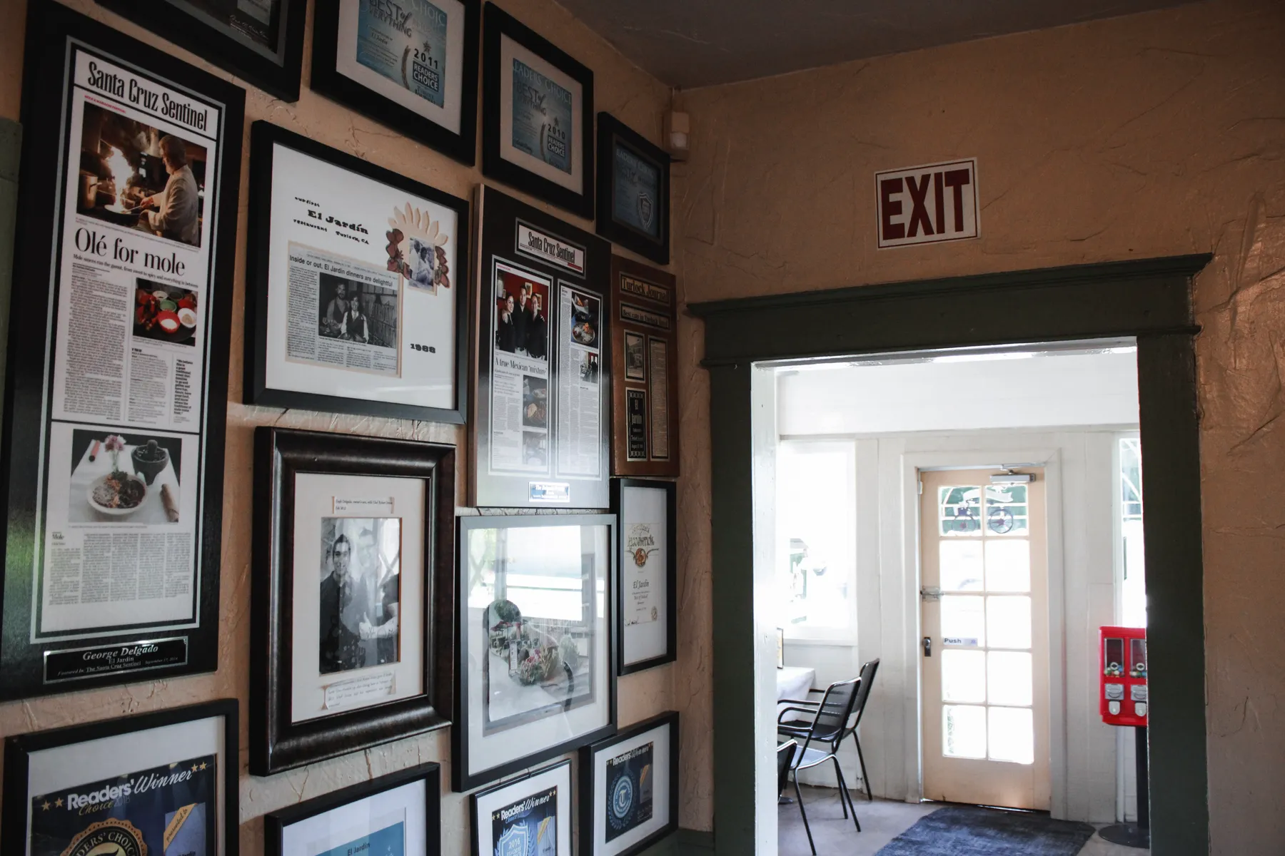 Wall of framed press clippings and Reader's Choice awards at El Jardín